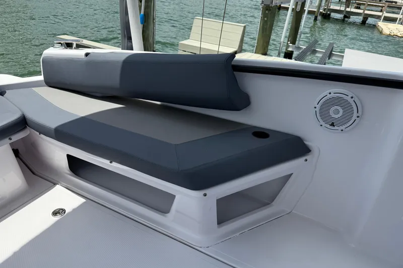 Slide: The Image of 2023 Axopar 25 Cross Top boat interior with cushioned seating and speaker. - 22
