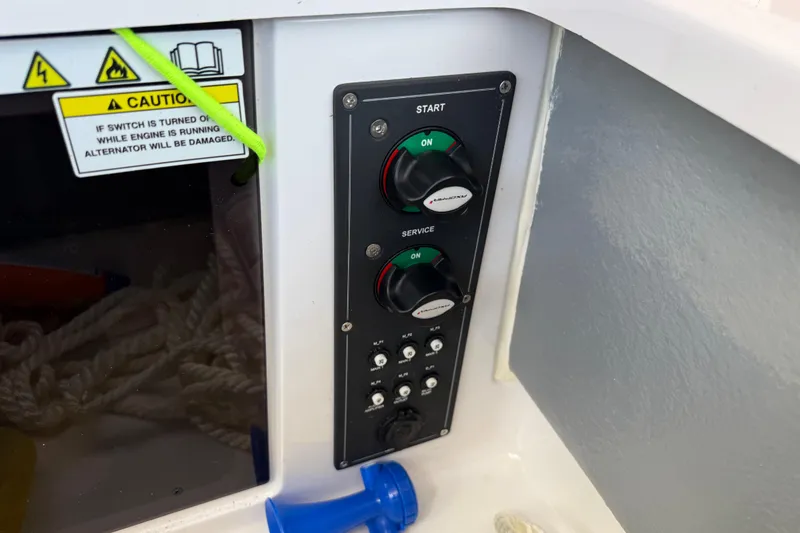 Slide: The Image of Control panel on 2023 Axopar 25 Cross Top boat with caution label and switches. - 25