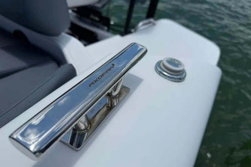 Slide: The Image of 2023 Axopar 25 Cross Top boat cleat detail with water in background. - 26