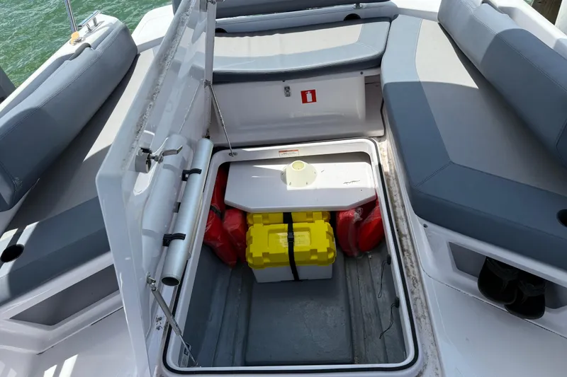 Slide: The Image of 2023 Axopar 25 Cross Top boat storage compartment with safety equipment and seating. - 28