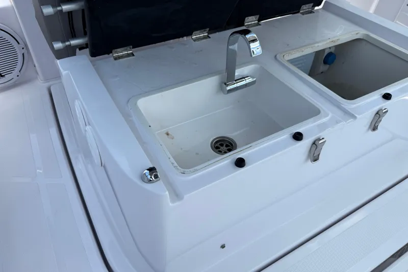 Slide: The Image of 2023 Axopar 25 Cross Top boat sink and storage compartments. - 31