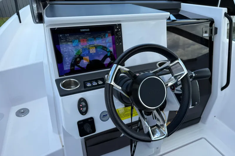 Slide: The Image of 2023 Axopar 25 Cross Top boat dashboard with steering wheel and Simrad display. - 34