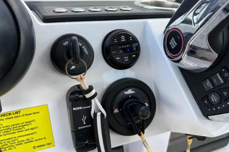 Slide: The Image of 2023 Axopar 25 Cross Top dashboard with controls and audio system. - 37