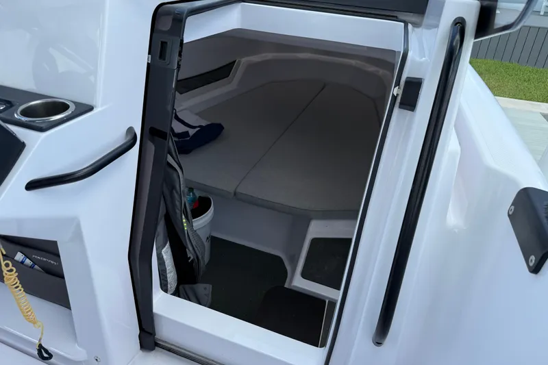 Slide: The Image of 2023 Axopar 25 Cross Top cabin interior with seating and storage space. - 41