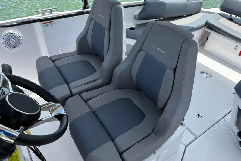 Slide: The Image of 2023 Axopar 25 Cross Top boat interior with dual gray seats and steering wheel. - 42