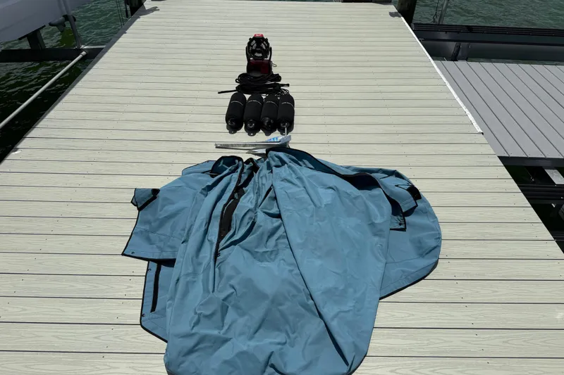 Slide: The Image of Diving gear and blue cover on dock near water, related to Axopar 25 Cross Top 2023. - 49