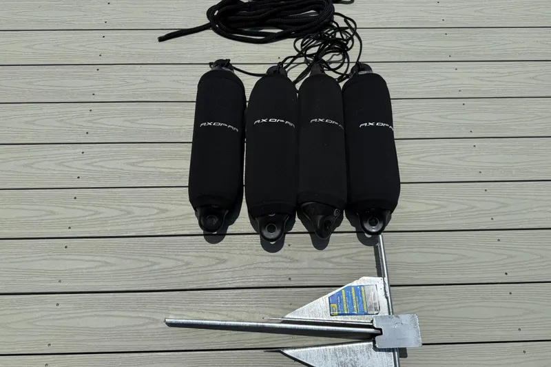 Slide: The Image of Four Axopar fenders and an anchor on a wooden dock. - 50