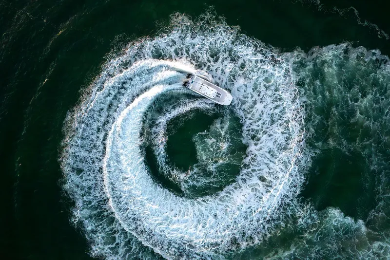 Slide: The Image of Aerial view of 2025 Invincible 36 Catamaran creating circular wake pattern in the ocean. - 13