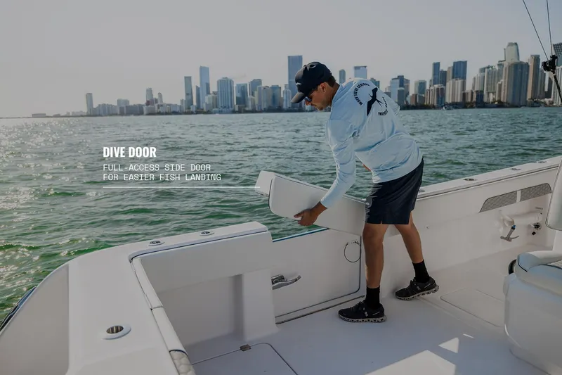 Slide: The Image of 2025 Invincible 36 Catamaran with dive door, city skyline in background. - 24