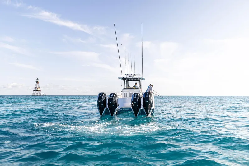 Slide: The Image of 2025 Invincible 36 Catamaran cruising on open sea with lighthouse in background. - 5