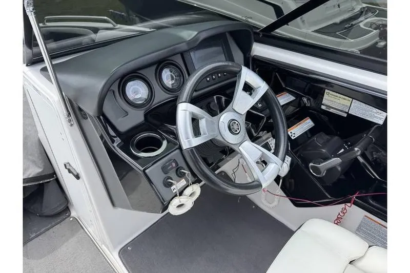 Slide: The Image of 2016 Yamaha AR240 boat cockpit with steering wheel and control panel. - 13