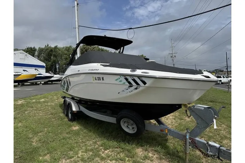 Slide: The Image of 2016 Yamaha AR240 boat on trailer, parked on grass under cloudy sky. - 2
