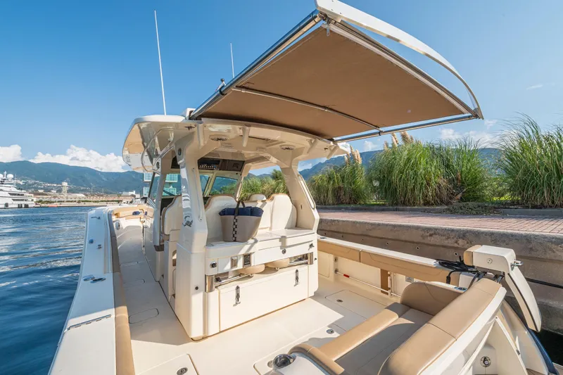 Slide: The Image of 2023 Scout 425 LXF luxury boat docked at marina, showcasing spacious deck and seating. - 12