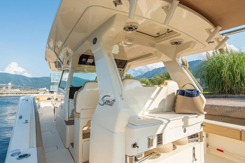 Slide: The Image of Luxurious 2023 Scout 425 LXF boat interior with plush seating, docked by scenic mountains. - 21