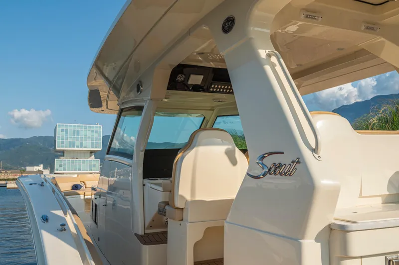 Slide: The Image of 2023 Scout 425 LXF boat with luxurious seating and sleek design, docked at marina. - 27