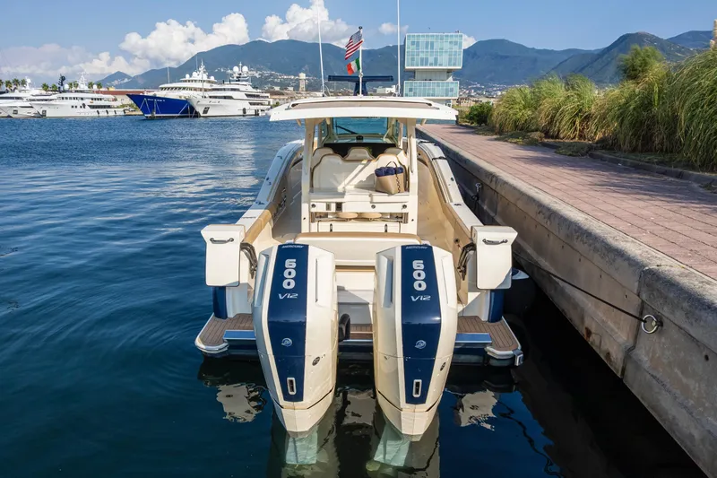 Slide: The Image of 2023 Scout 425 LXF boat with dual Mercury engines docked in scenic marina. - 3