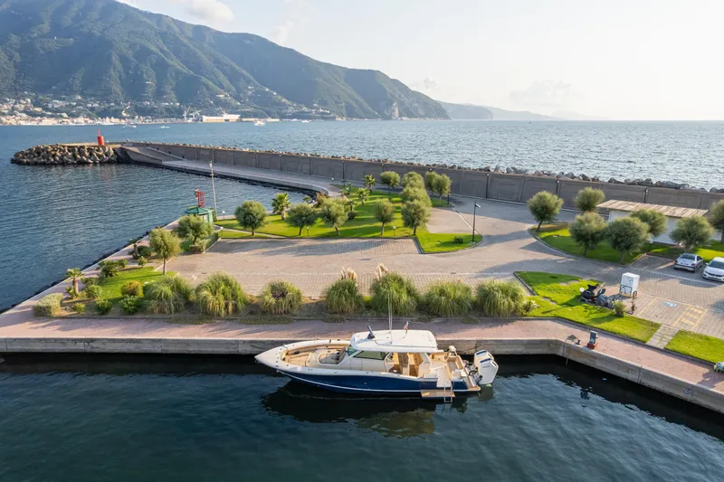 Slide: The Image of 2023 Scout 425 LXF yacht docked at scenic marina with mountain backdrop. - 35