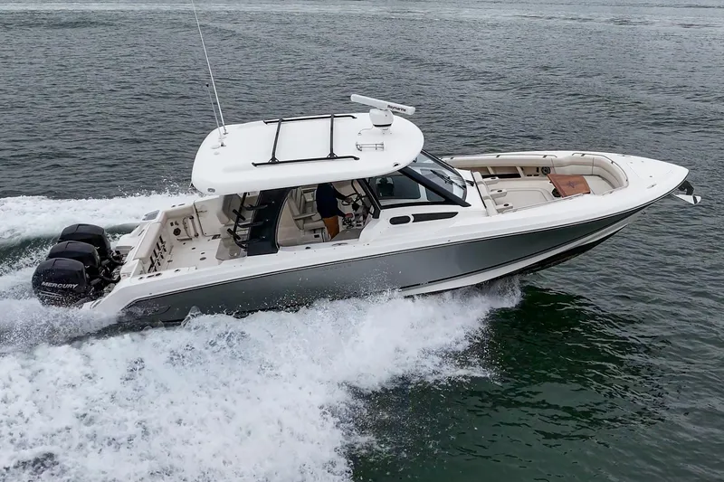 Slide: The Image of 2022 Boston Whaler 350 Realm cruising on open water, showcasing sleek design and powerful engines. - 11