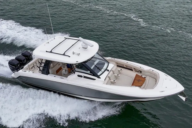 Slide: The Image of 2022 Boston Whaler 350 Realm cruising on water, showcasing sleek design and powerful engines. - 12