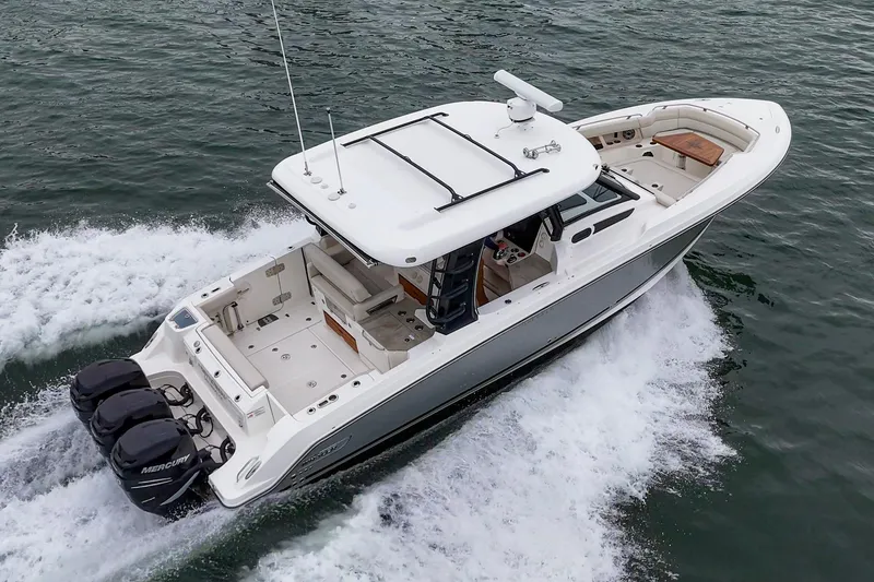 Slide: The Image of 2022 Boston Whaler 350 Realm cruising on water, showcasing sleek design and powerful engines. - 13