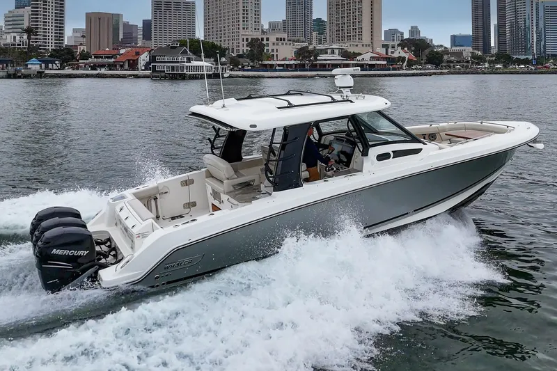 Slide: The Image of 2022 Boston Whaler 350 Realm cruising in urban waterfront setting. - 14