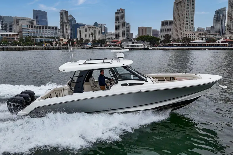Slide: The Image of 2022 Boston Whaler 350 Realm cruising in urban waterfront setting. - 15