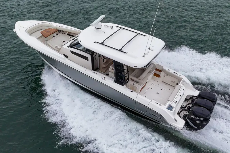 Slide: The Image of 2022 Boston Whaler 350 Realm cruising on water, showcasing sleek design and powerful engines. - 2