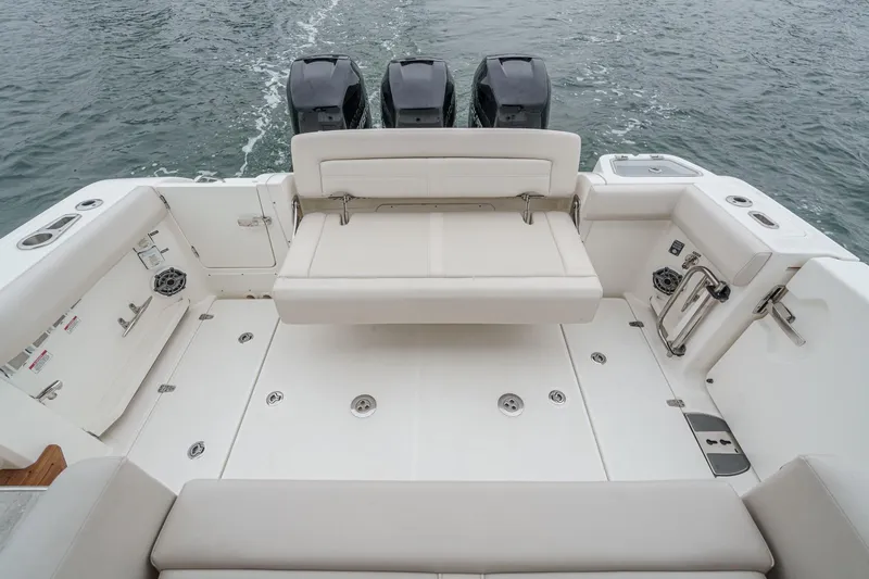 Slide: The Image of 2022 Boston Whaler 350 Realm boat interior with seating and triple outboard engines. - 21