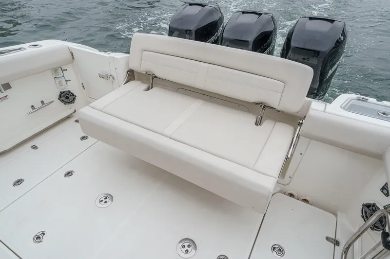 Slide: The Image of 2022 Boston Whaler 350 Realm boat with cushioned seating and triple outboard engines. - 22