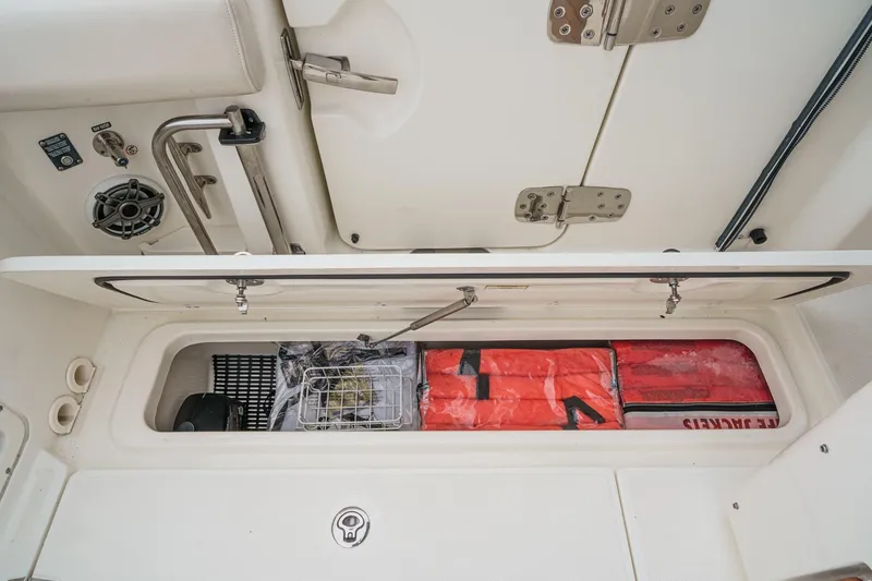 Slide: The Image of 2022 Boston Whaler 350 Realm storage compartment with life jackets and safety equipment. - 28