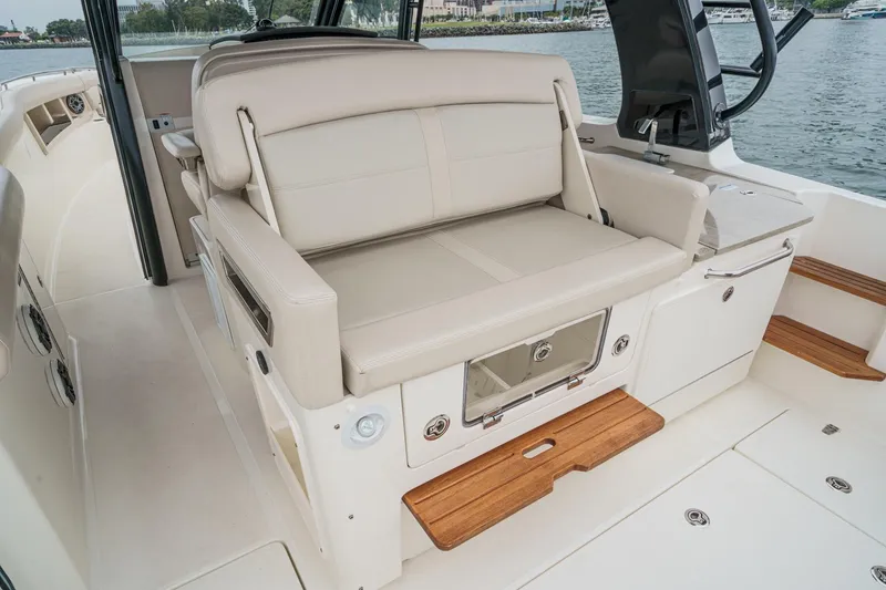 Slide: The Image of Luxurious seating area on 2022 Boston Whaler 350 Realm boat, featuring beige upholstery and wooden accents. - 30