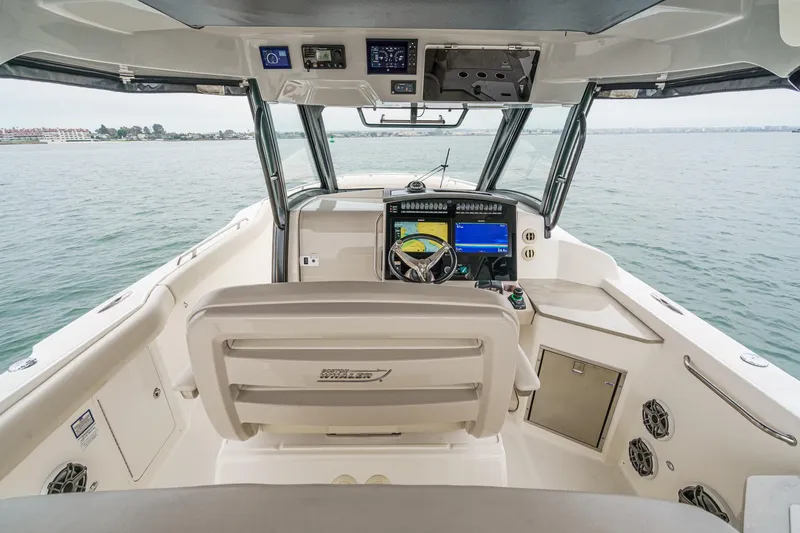 Slide: The Image of 2022 Boston Whaler 350 Realm cockpit with advanced navigation system, steering wheel, and ocean view. - 37