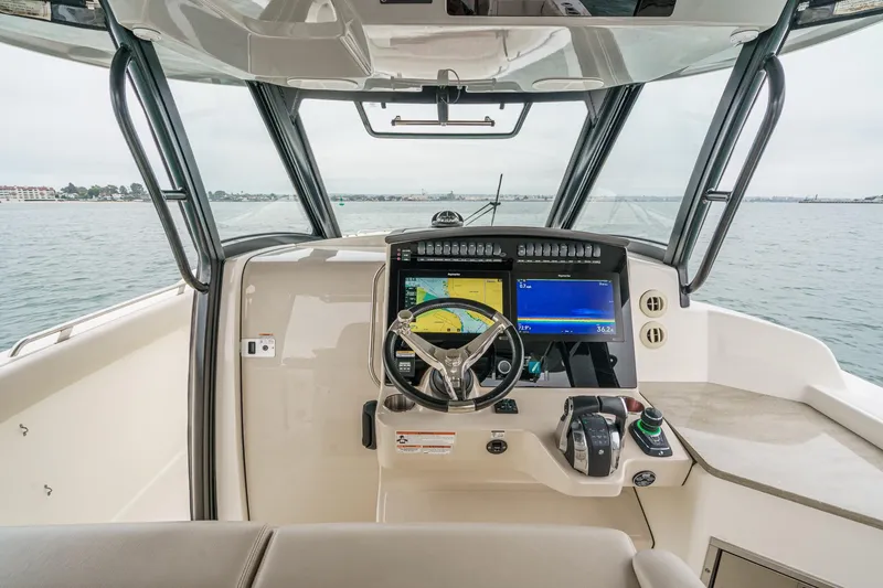 Slide: The Image of 2022 Boston Whaler 350 Realm helm with advanced navigation displays on open water. - 38