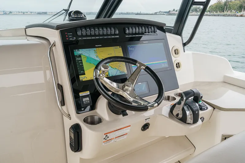 Slide: The Image of Control panel of 2022 Boston Whaler 350 Realm with navigation screens and steering wheel. - 39