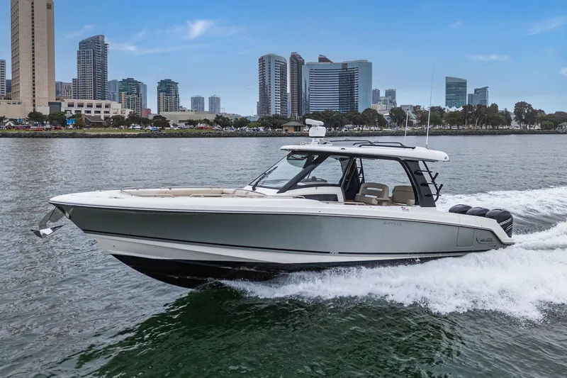Slide: The Image of 2022 Boston Whaler 350 Realm cruising on water with city skyline backdrop. - 4