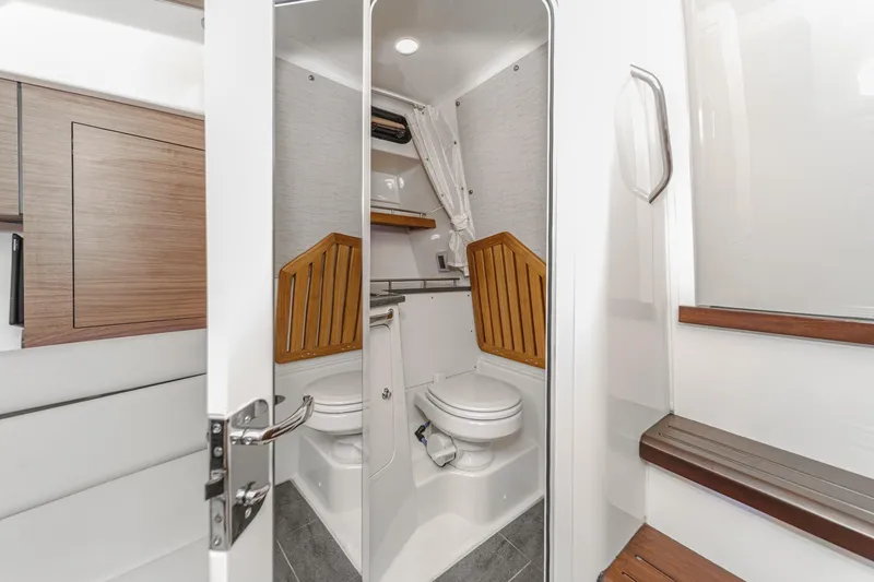 Slide: The Image of 2022 Boston Whaler 350 Realm boat interior bathroom with modern design and wooden accents. - 64