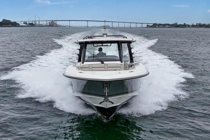 Slide: The Image of 2022 Boston Whaler 350 Realm cruising on open water with bridge in background. - 7
