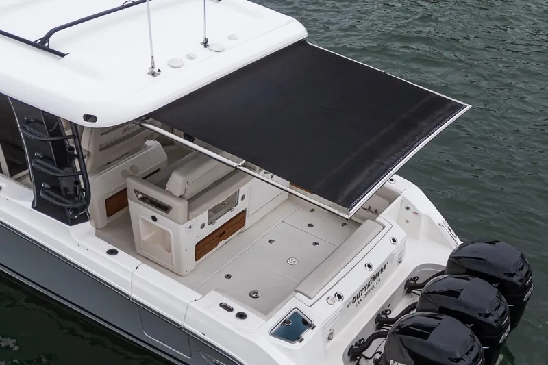 Slide: The Image of 2022 Boston Whaler 350 Realm boat with extended sunshade, docked on water. - 79