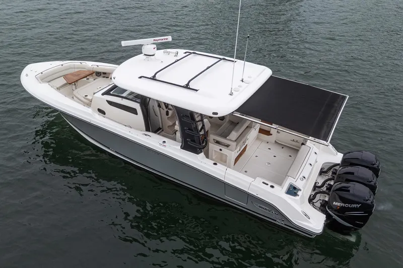 Slide: The Image of 2022 Boston Whaler 350 Realm boat on water, featuring triple Mercury engines. - 80