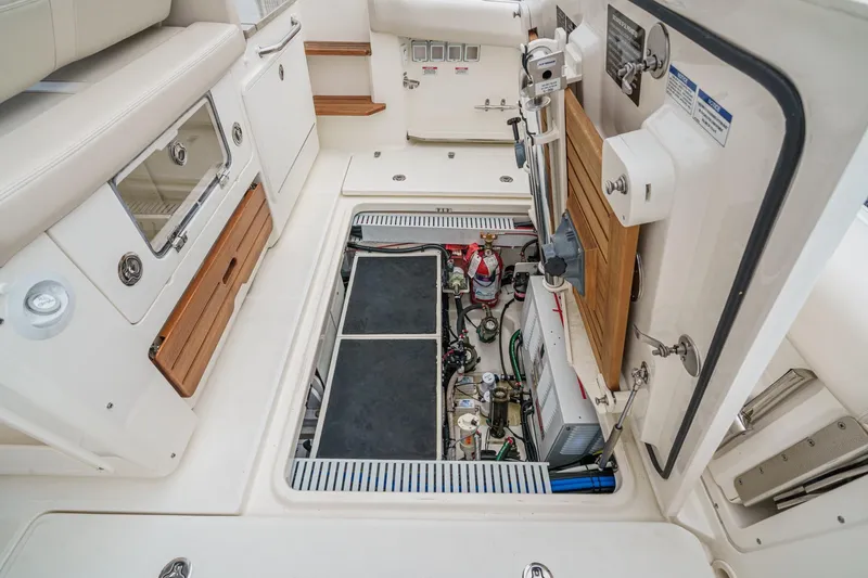 Slide: The Image of 2022 Boston Whaler 350 Realm boat interior, showcasing storage and mechanical compartments. - 86