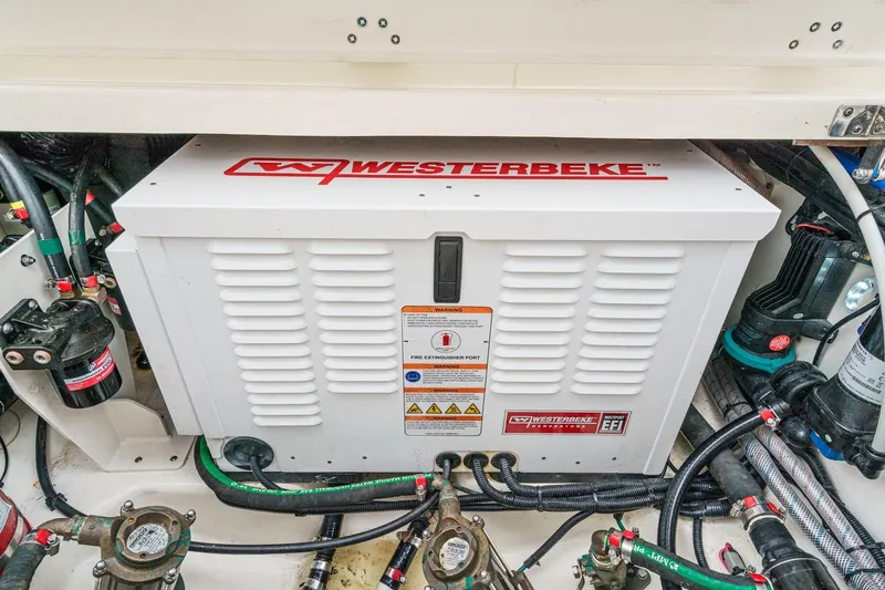 Slide: The Image of Westerbeke generator in 2022 Boston Whaler 350 Realm engine compartment, surrounded by cables and components. - 88