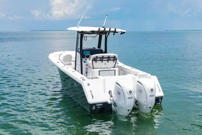 Slide: The Image of 2026 Sea Hunt Gamefish 25 boat with dual Yamaha engines on calm water. - 1