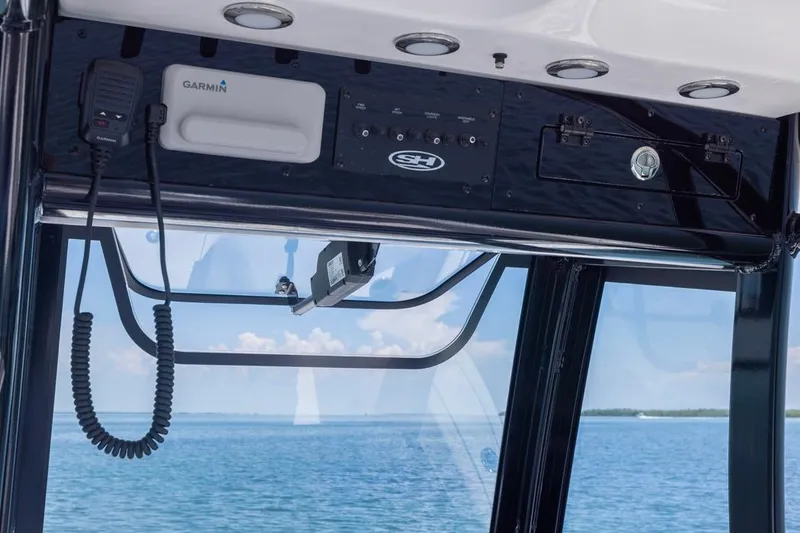 Slide: The Image of 2026 Sea Hunt Gamefish 25 boat console with Garmin equipment, ocean view in background. - 12