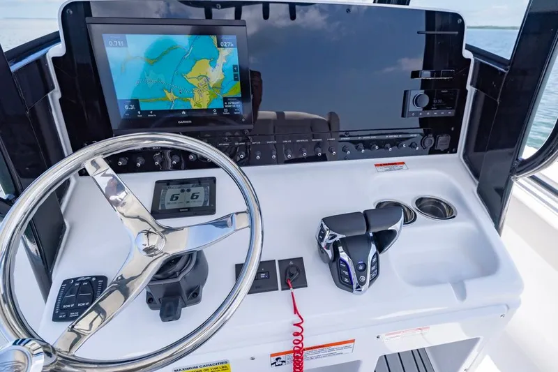 Slide: The Image of 2026 Sea Hunt Gamefish 25 helm with navigation display and controls. - 13