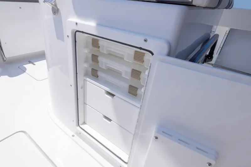 Slide: The Image of 2026 Sea Hunt Gamefish 25 boat storage compartment with tackle boxes and drawers. - 17