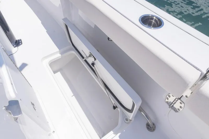 Slide: The Image of 2026 Sea Hunt Gamefish 25 boat storage compartment with open hatch and cup holder. - 20