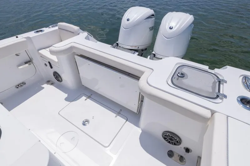 Slide: The Image of 2026 Sea Hunt Gamefish 25 boat interior with dual engines, white seating, and storage compartments. - 21