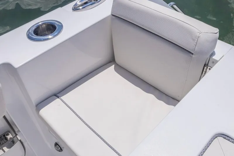 Slide: The Image of 2026 Sea Hunt Gamefish 25 boat seat with cup holder, featuring white upholstery. - 24