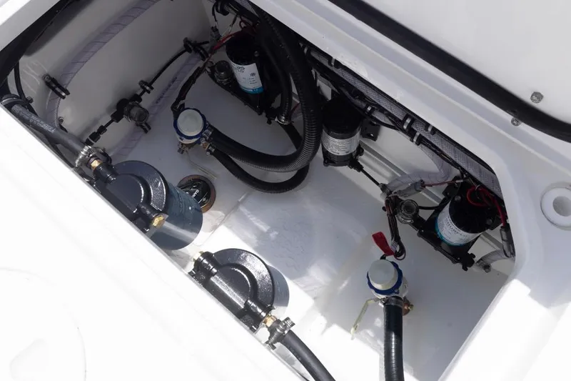 Slide: The Image of 2026 Sea Hunt Gamefish 25 boat engine compartment with hoses and filters. - 27