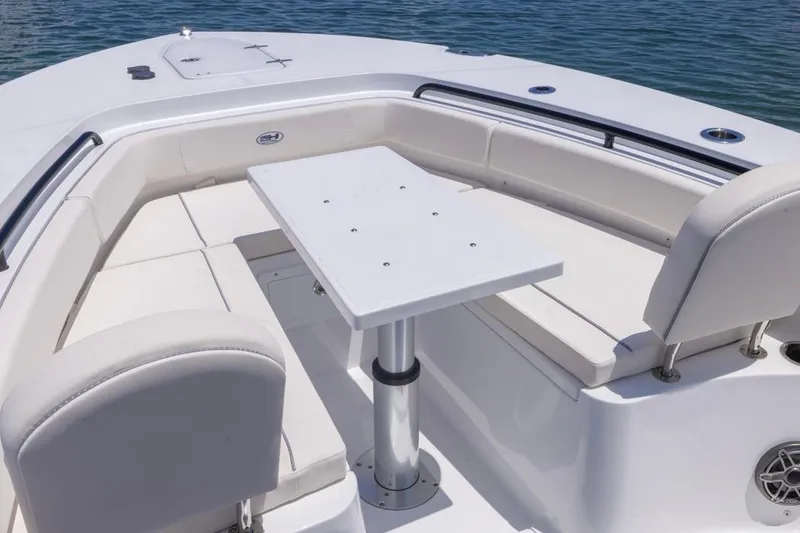 Slide: The Image of 2026 Sea Hunt Gamefish 25 boat interior with seating and table on calm water. - 7